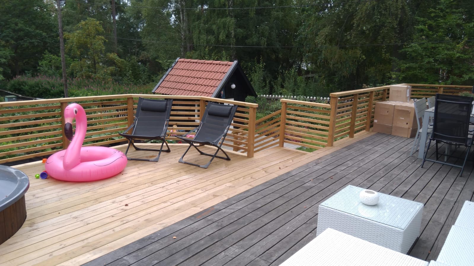 Stor altan med vågformat insynsskydd i trä och plats för spabad