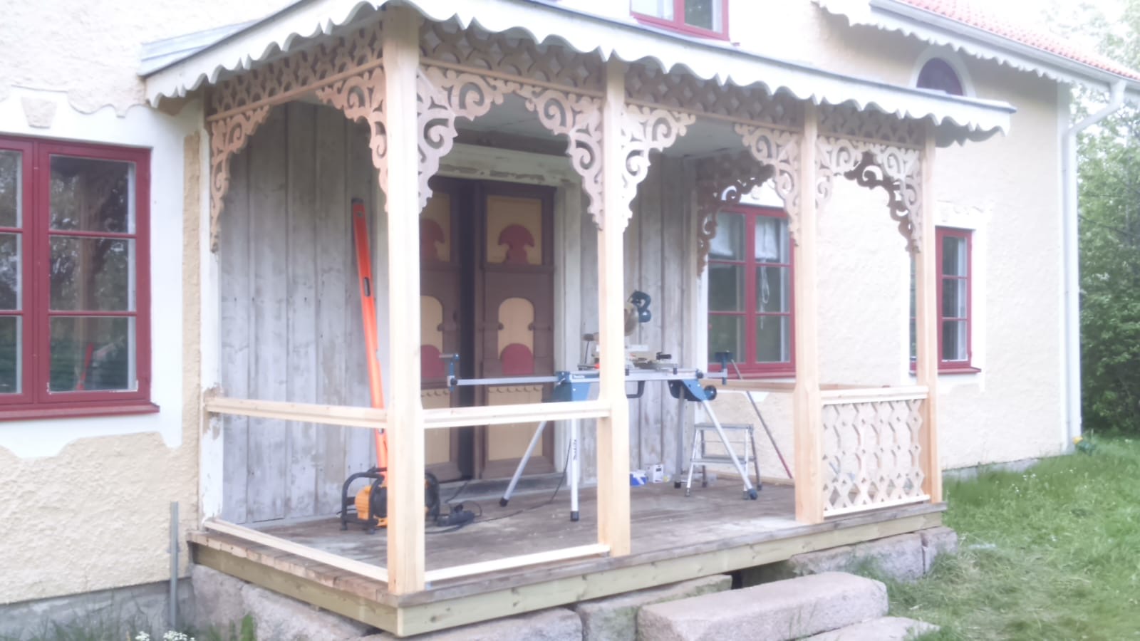 Renoverad veranda med återställda trädetaljer