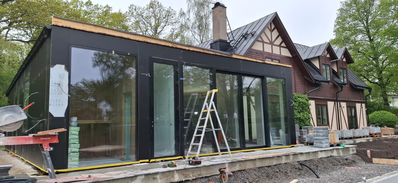 Tillbyggnad med stora glaspartier under byggnation