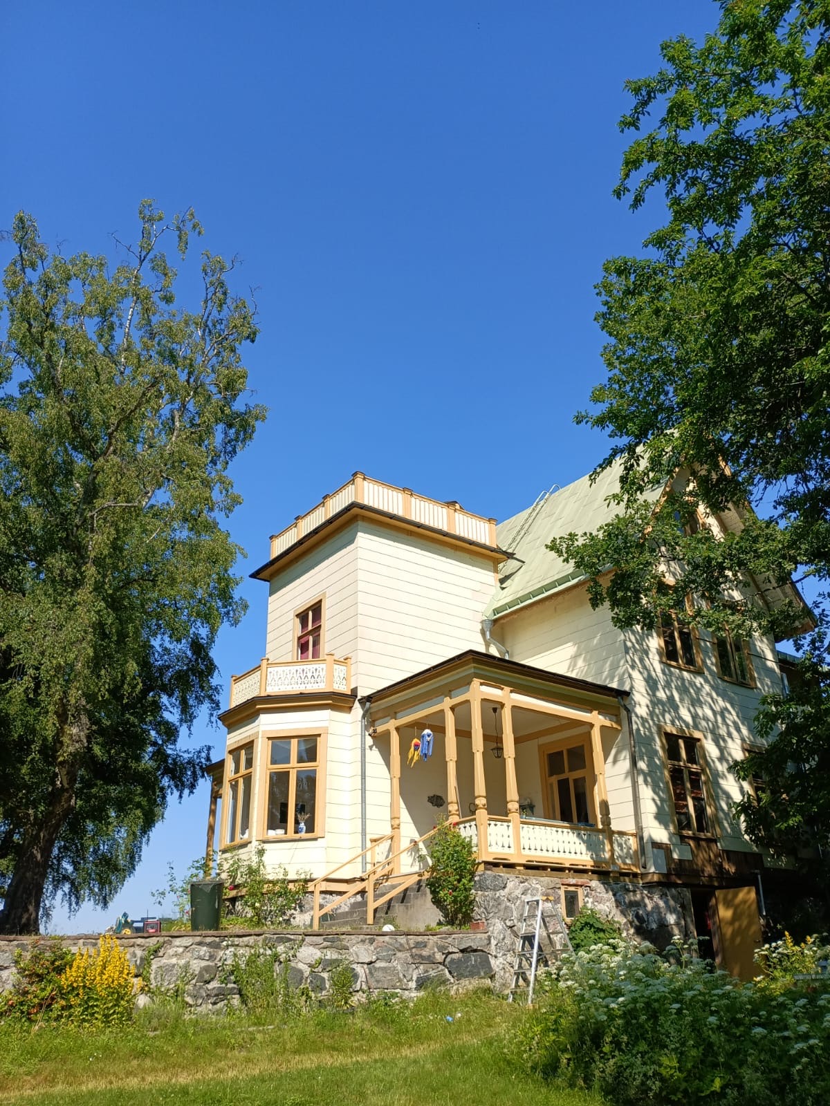 Renoverad trävilla med veranda och snickeridetaljer