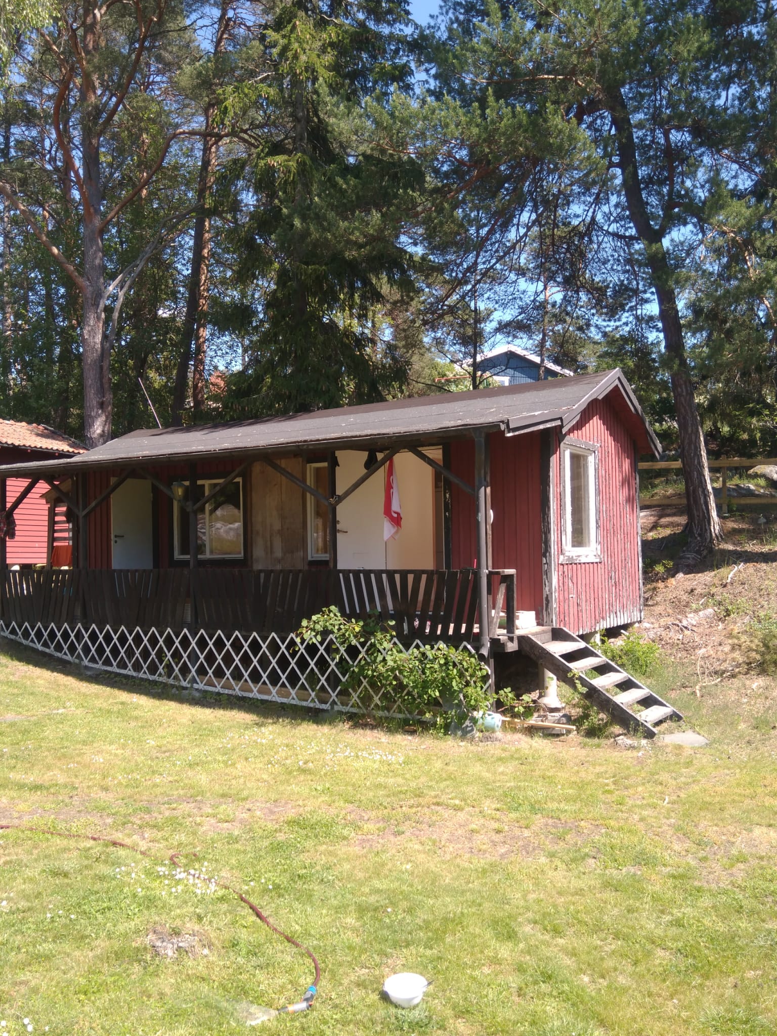 Röd stuga med renoverad veranda